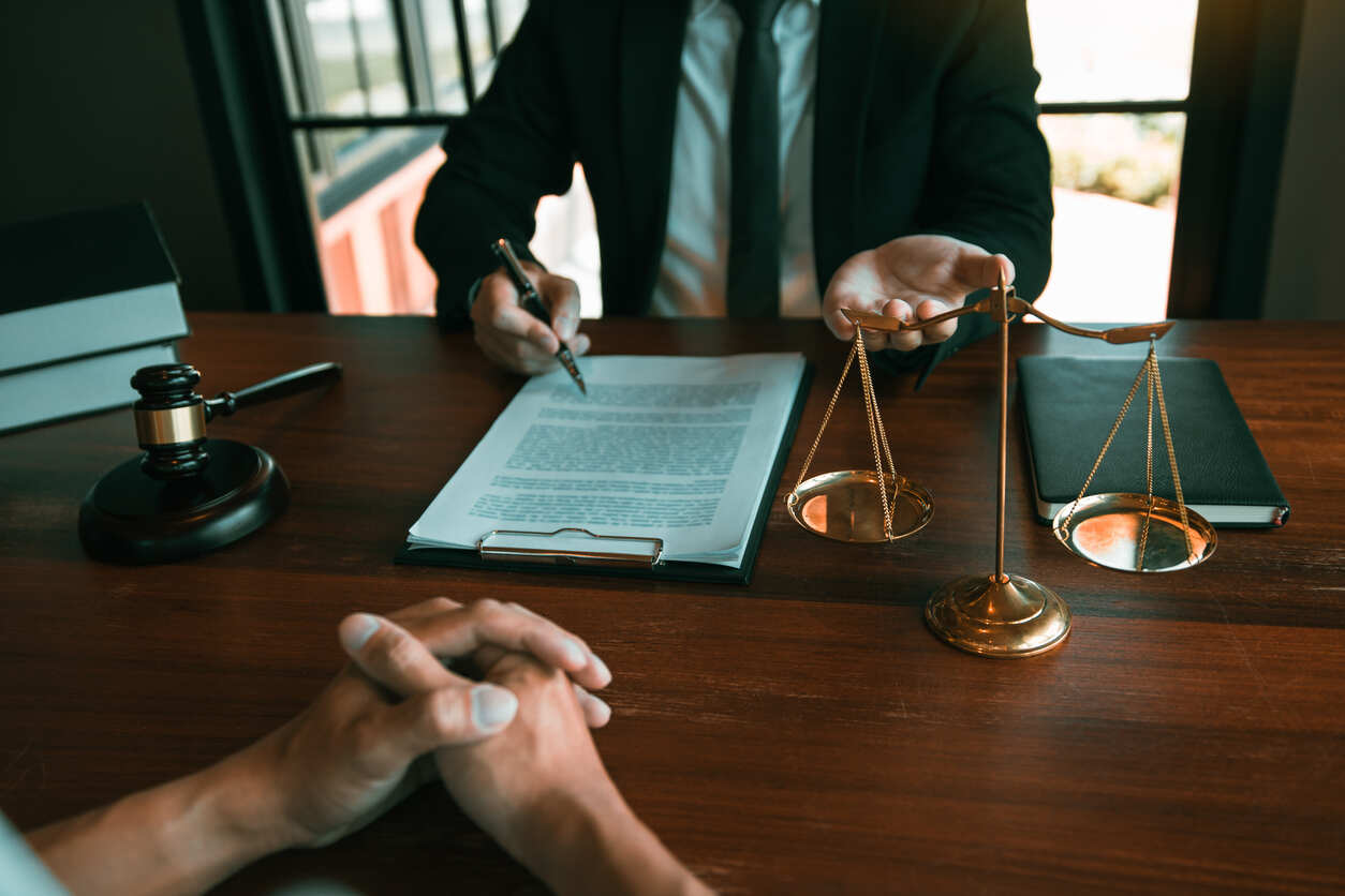 Legal meeting with a client and lawyer reviewing paperwork related to a rear-end truck accident claim in El Paso, Texas.