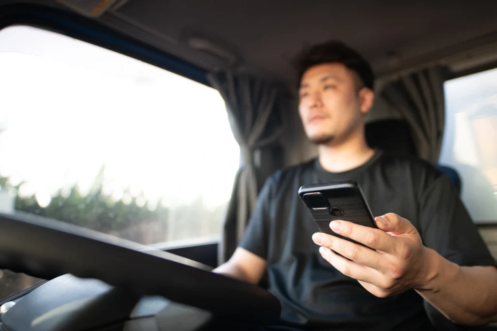 Truck driver distracted by phone, increasing risk due to size, weight, and limited maneuverability.