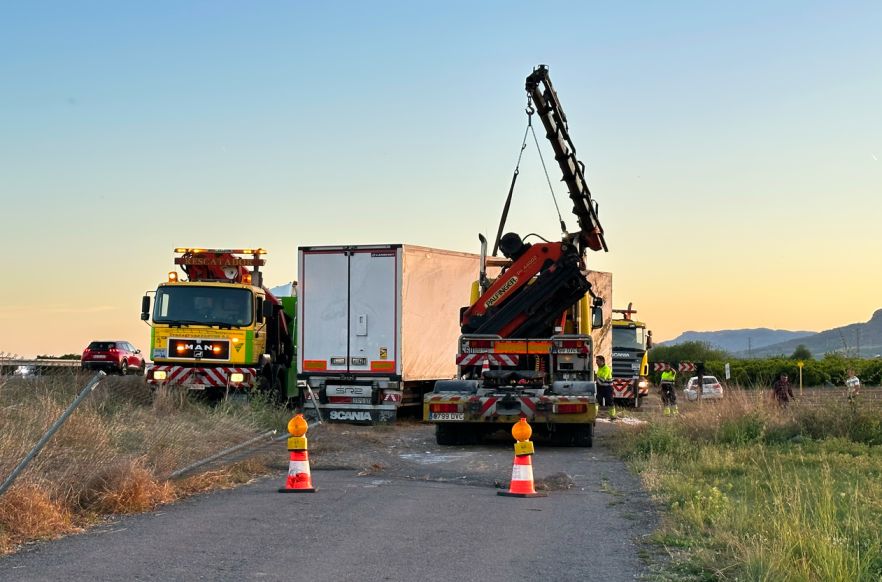Accidente de camión en Las Cruces con grúa levantando el remolque y equipos de emergencia en la zona.